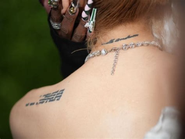 What does Ariana's back tattoo say?